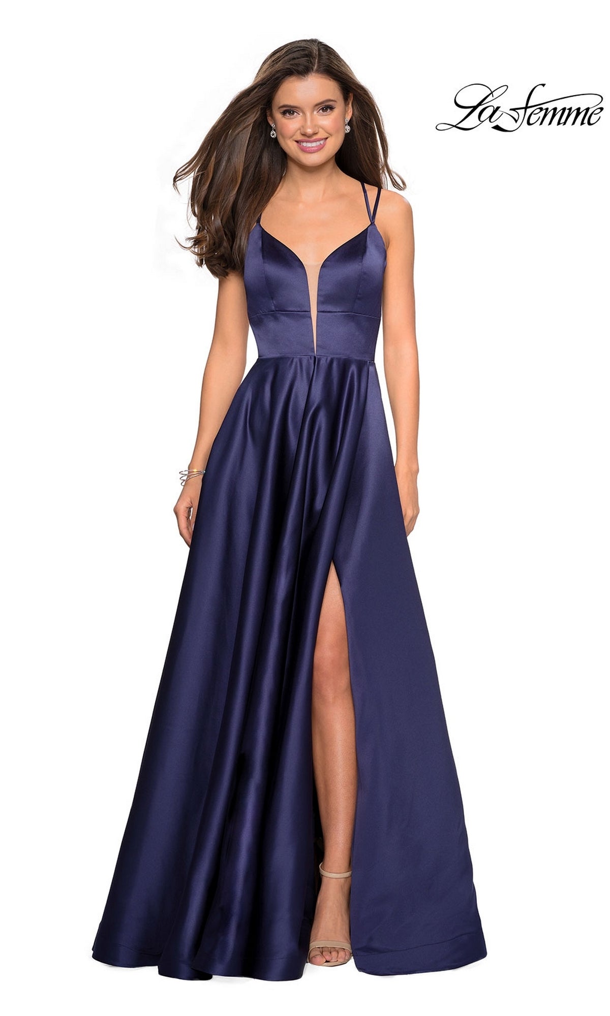 Woman in a La Femme Deep V-Neck Long A-Line Prom Dress 26994 in Navy, featuring a fitted bodice, open back, thigh-high slit, and spaghetti straps, smiling while standing.